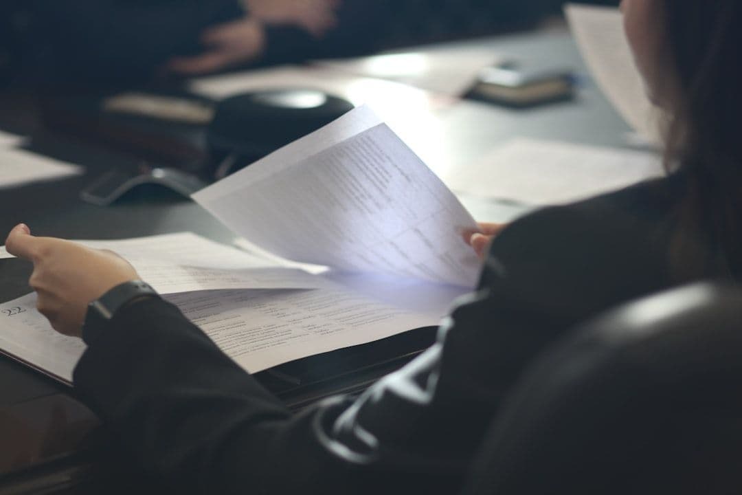 Professional carefully reviewing a document at a desk